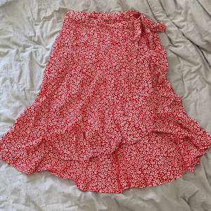 Röd/vit blommig kjol med knytning i sidan i storlek M men passar även S🤍 Helt oanvänd
