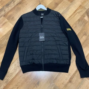 Barbour cardigan  - Tja säljer nu min helt nya Barbour cardigan i storlek M. Aldrig använd och säljer den för att jag har inget behov av den. Perfekt nu till våren när det börjar bli lite varmare ute. Hör av er om ni har några funderingar. Priset är fast inga prutningar