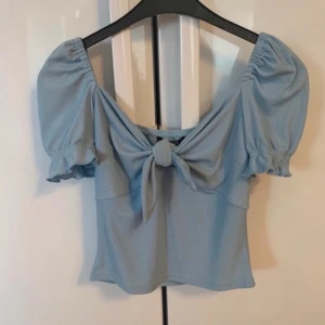 Blå ribbad topp blus kort croptop knyt snöre rosett detaljer puffärm stockholmstil - Fint skick, använd enstaka gång.