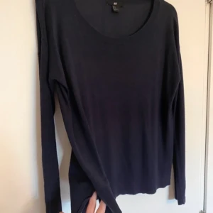 Blå mörkblå marinblå tröja topp detaljer slits stockholmstil stockholmsstil coquette - En mörkblå långärmad tröja med slits. Inga hål eller fläckar, men är lite luddig/nopprig över hela.