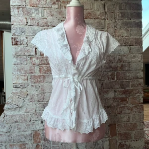 Blus - Blus med snörning i midjan och blom detaljer🤍 står storlek 42 men kan spännas så den sitter som en S/M🤍