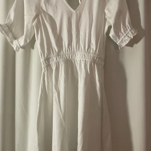 Vit klänning  - En superfin klänning från bubbleroom. Storlek 36, jag är 160 cm lång och den passar bra på mig. Endast använd 1 gång. Väldigt lätt och skönt material. Svart kan synas lite igenom men inte vit t.ex.  