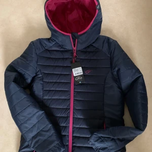 Dunjacka, dam, L - Lätt, smidig och varm dunjacka som håller dig behagligt varm under kalla dagar. Huvan ger extra skydd mot väder och vind.  Five Seasons Ace Jacket passar perfekt till vardags som fritidsjacka eller som ett innersta lager under en skaljacka i kallt oc