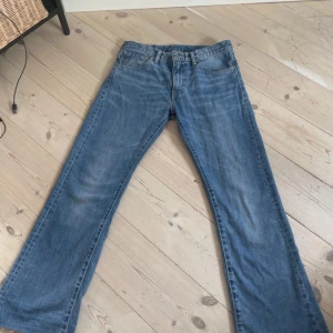 Jeans levis - Ett par mellan/ljusblå Levis jeans i modellen 527 storlek 32/32. De har blivit avklippta av tidigare ägare så längden stämmer inte överens. De har även en liten fläck på vänstra benet lite längre ner men är inget man tänker på när man har på sig dem.