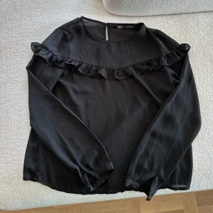 Svart blus med volang - Super fin svart blus med volang i bröstet från Only.  Den är såå fin men tyvärr för liten för mig nu 😭.   Köp, köp, KÖP 💕