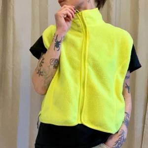 Gul fleeceväst Weekday - Neongul fleeceväst med zip och fickor. Aldrig använd så i bra skick. Strl M, ganska bred modell. Snygg att ha över jackor. Tunn men ändå ganska varm. 