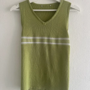 Grön väst - Grön stickad väst, tunn i tyget. Står ingen strl men skulle säga en M. Den har inget mönster i sig, vet inte varför min kamera skapade sånna skuggor 😅 