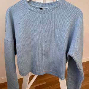 Blå tunnare stickad tröja från Gina Tricot. Croppad modell. Storlek XS, passar även storlek Small. 