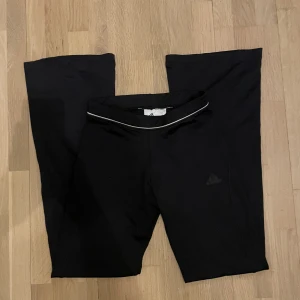 Bootcut adidas byxor - Ett par svarta adidas leggings som är bootcut/utsvängda. Super skick, inga fläckar eller hål. Storlek S men jättestretchigt material. Brukade vara en adidas logga på framsidan som trillade av, syns på bild 4. Knappt synligt när byxorna är på.
