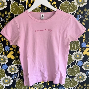 Sex And The City T-Shirt! - Original merch från HBO för serien Sex and the city.  Babytee stil där T-shirten slutar runt höfterna vilket ger en väldigt fin figur och funkar med allt från låg till hög-midjade byxor!  Storlek M men passar jättebra för S och XS med 💓🌸