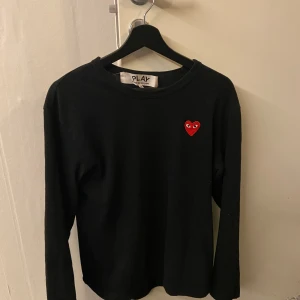 Cdg tröja - En stilig Cdg tröja. Tröjan är knappt använd därav dess skick som är 10/10. Märket är väldigt populärt nuförtiden och dessutom otroligt bekvämt. Vid frågor och funderingar så är det bara att höra av sig. Vid en snabb affär går priset ner mycket! 