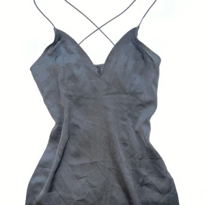 Miniklänning  - Miniklänning från PrettyLittleTings. Band som korsas i ryggen. Figurnära, ger fina former 🖤🪩👯‍♀️