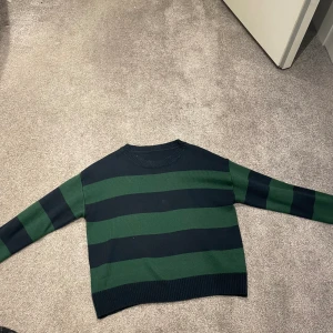 Stickad randig tröja  - Stickad tröja, mörkblå och mörkgrön randig. Fint skick, knappt använd