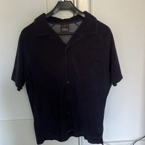 Kortarmad skjorta från Oscar Jacaboson - Kortarmad skjorta i frottematerial Oscar Jacobson Färg: Marinblå  Skick 9/10 Storlek: M Nypris: 999kr