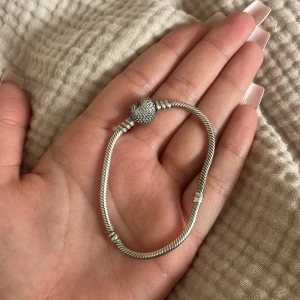 Pandora armband  - Säljer mitt Pandora armband i sterlingsilver! Köpte armbandet men även berlockerna i januari detta året, säljer pga ska köpa ett guld istället. Skicket e helt nytt. Näst minsta storlek på armbandet (17 cm). kolla profil för bilder på berlocker till🤍