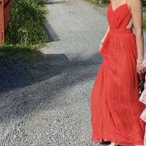 Balklänning - Orange/rosa balklänning från by Malina i 100% silke, storlek S.  Endast använd en gång och i jättebra skick! Öppen rygg med knytband. Den är lång och passade mig bra i längden som 170 cm plus klackar! Pris kan gå ner vid snabb affär! Nypris ca 4500kr