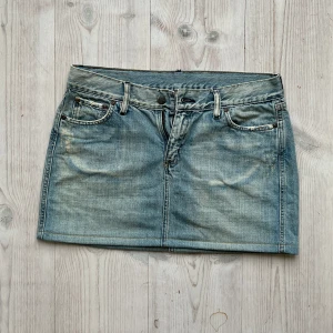 Lågmidjad jeanskjol  - Lågmidjad ljusblå jeanskjol från Gul&Blå som jag har sytt upp från en längre kjol. Storlek M och tvärs över midjan är det 39 cm. Använd gärna köp nu!