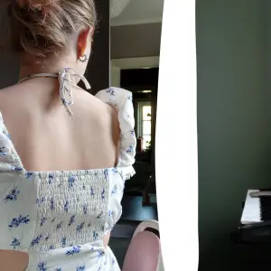 En vit klänning med super söta blåa blommor på, fick den av en kompis i år hon köpte den förra året, inga tecken på andvändning❤️