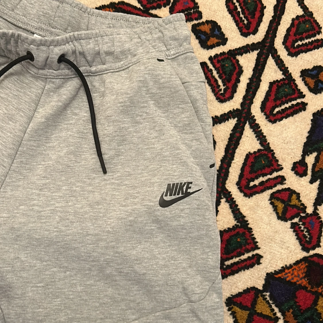 Gråa Nike tech byxor - 92