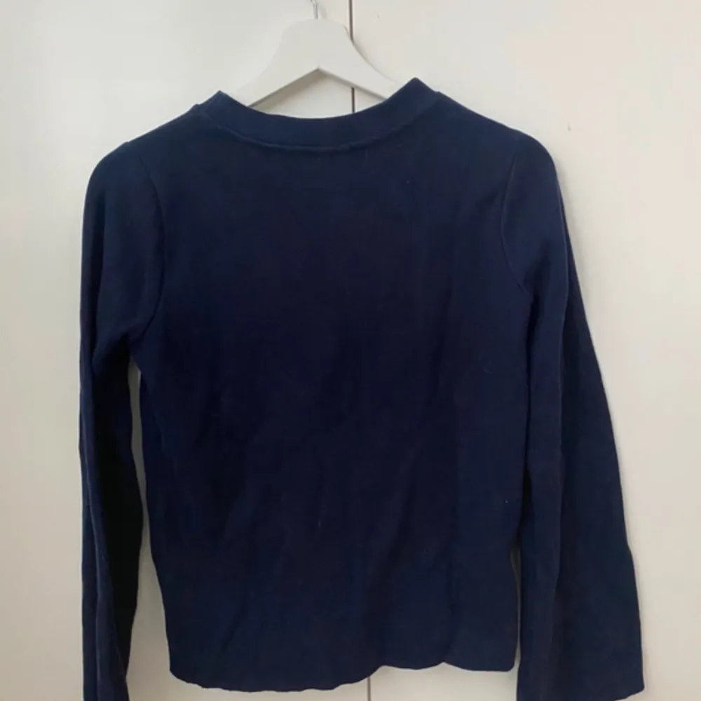 Blå långärmad tröja med lite vidare ärmar och lite kortare längd . Tröjor & Koftor.