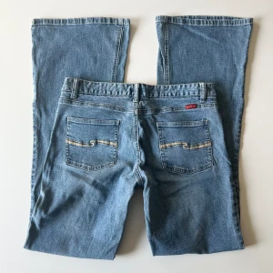 Lågmidjade jeans - Vintage lågmidjade bootcut jeans från Tilt. Midjemått: 78 cm, stretch. Innerbenslängd: 82 cm. Inga defekter förutom ett igensytt hår på höger ben. Modellen är 167 cm lång. Skriv privat för mer bilder och mått! 💕