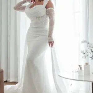 Den vackraste brudklänningen som är sydd och designad av LY Couture Stockholm. Inköpt juli 2023 för 35.000 kr. Brudklänning med korsett och tyg från Italien. Sydd slöja 3 meter, avtagbara ärmar och överkjol, avtagbar rosett till klänningen. Som ny.