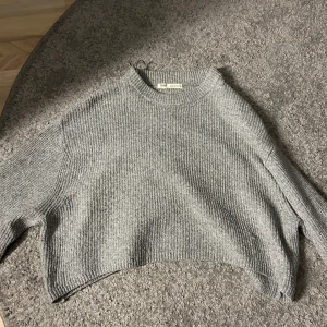 Stickad tröja - Säljer denna gråa fina stickade tröja från Pull&Bear då den tyvärr inte kommer till användning. Skulle säga att den är lite kortare(magtröja) Säljer för 200kr då det finns en liten fläck🩶