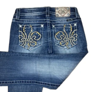 MISS ME JEANS - Miss Me jeans i modellen ”signature/boot” midjemåttet rakt över är 38cm. Ytterbenet 110cm och innerbenet 87cm. Jeansen är som helt nya. Kontakta vid intresse!