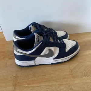 Nike dunk low Midnight navy - Nike dunk storlek 43. De är använda men i ett bra skick, lite slitna längst fram på vänster sko och lite creasade men annars bra. Hör av dig om du har frågor ✌️
