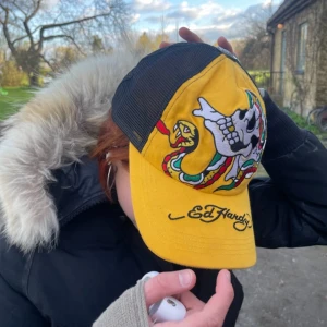 Ed Hardy Keps - En jättecool gul ed hardy keps 💛! Fint skick, inga defekter. Kan skicka fler bilder vid behov! Jag har själv köpt den på secondhand så vet inte om den är äkta men kvaliten är jättefin!