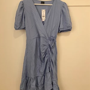 Ljusblå klänning - Ljusblå klänning från Gina Tricot med volangdetaljer & puffärmar  