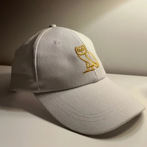 OvO Keps - Vit keps med broderad OVO-logga i guld och strap-back. Säljer pga att den inte passar mig. Skicket är som ny, men inte den dyraste kvaliten på materialen, därav priset. Kanske kan sänka till 150 vid snabb affär!