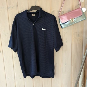 Nike Airliner Polo, XL - Unisex oversized Nike-tröja i fint begagnat skick. Det finns en liten spricka, vänligen se sista bilden för detaljer.Tröjan passar de flesta storlekar eftersom den är oversized.  