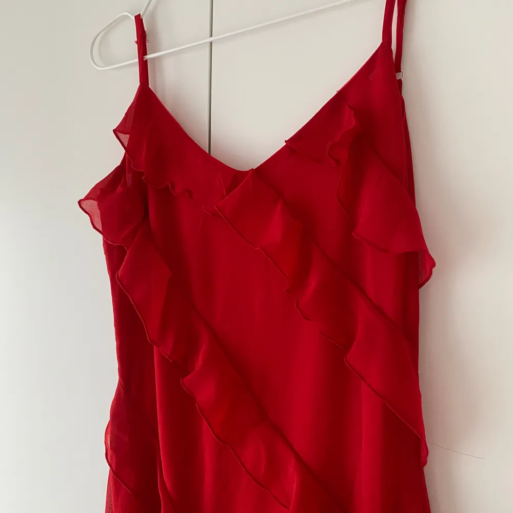 Röd långklänning med volanger och djupare rygg. Reglerbara band, underklänning och dragkedja i sidan. Oanvänd och i bra skick! Säljer då jag valde en annan färg. Str S men passar för XS/S ✨. Klänningar.