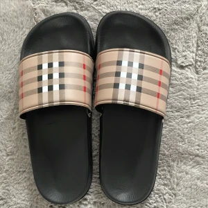 Burberry Tofflor - Hej, Säljer dessa helt nya Burberry tofflor, Har aldrig använt de. För endast 299 kr!