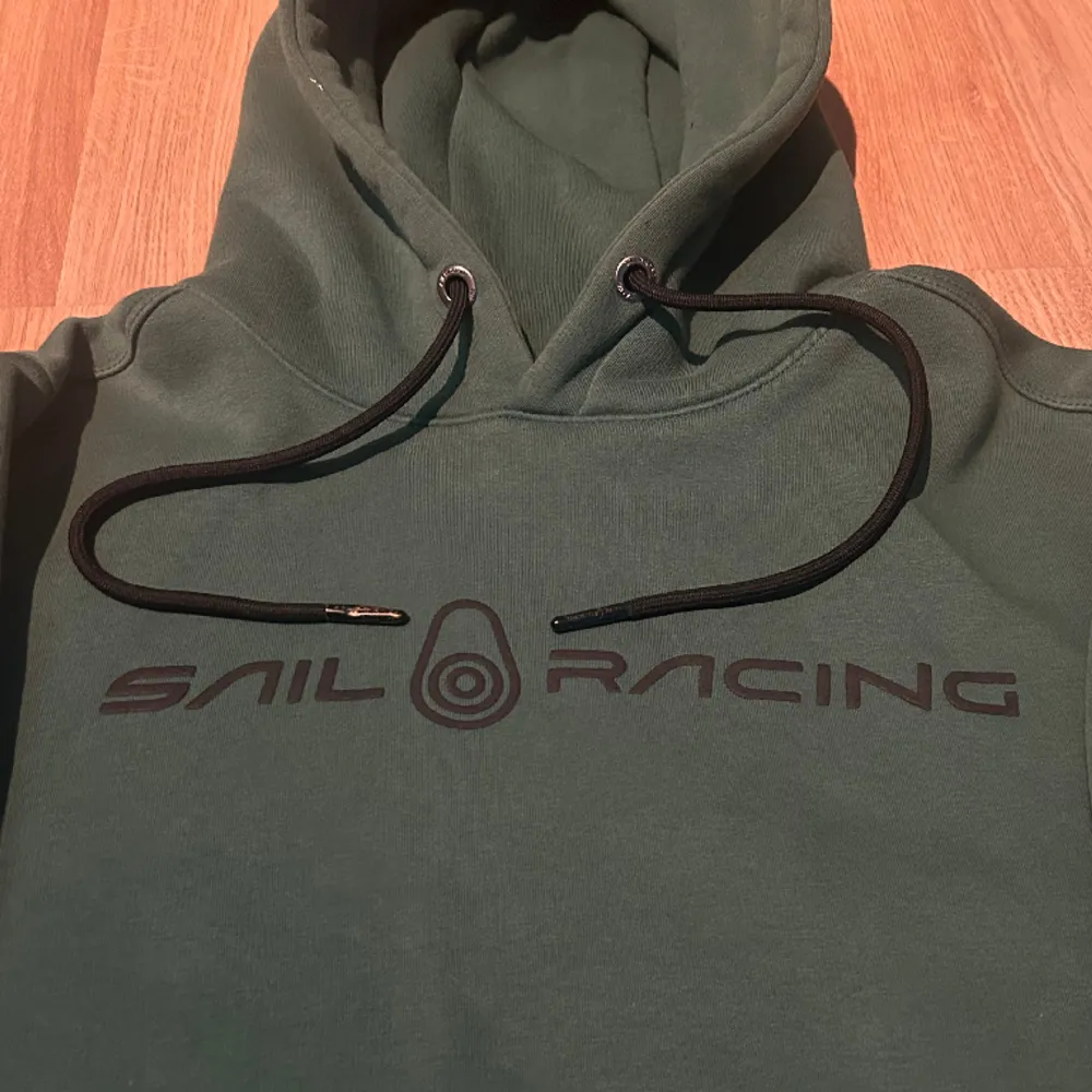 Säljer min gröna Sail Racing hoodie då den har blivit för liten för mig. Den är i bra skick och inga tydliga tecken på användning förutom att änden på snörena är lite slitna (se bild 2). Priset går att diskuteras vid snabb affär.. Hoodies.