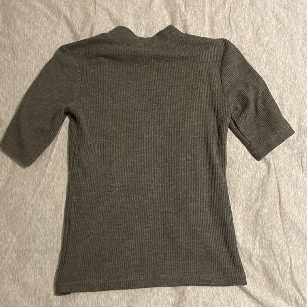 1 st grå stickad kortärmad tröja. Använd ett fåtal gånger och säljs pga att den är för liten. Skriv för fler bilder. T-shirts.