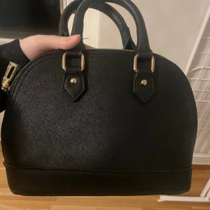 svart väska - Säljer pga jag inte anvönder längre. Endast använd ett fåtal gånger. Perfekt skick och inga defekter. Vet inte vilket märke. 