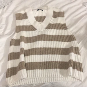 En stickad tröja utan armar vitt,bruna Ränder💗 - Stickad tröja utan armar från Gina storlek M tyvärr för stor. Orginal pris 357kr får för 200kr!!!