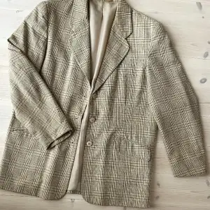 Rutig herrblazer köpt second hand. Lite nopprig i ärmsluten annars fint skick. Sitter ganska löst på mig som är en 38a, men passar alltifrån 36-40 beroende på hur oversize man vill ha. 