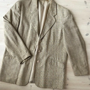 Rutig blazer - Rutig herrblazer köpt second hand. Lite nopprig i ärmsluten annars fint skick. Sitter ganska löst på mig som är en 38a, men passar alltifrån 36-40 beroende på hur oversize man vill ha. 