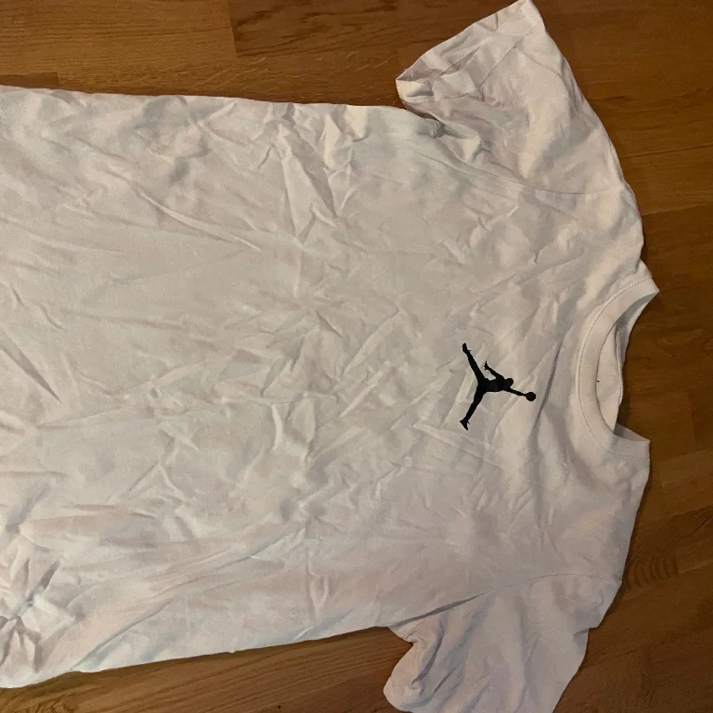 T-Shirt från NIKE:s Jordan-kollektion. Använd ett flertal gånger, men fortfarande hel. Förekommer en svart fläck (se bild) på den nedre, vänstra delen av ryggen på t-shirten.. T-shirts.