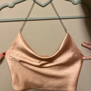 Topp - Jättefin fest topp, silkes material är lite rosa/beige skimmer med kedje band runt nacken, bar rygg perfekt till fest 