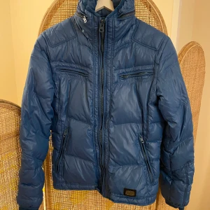 Diesel dunjacka  - Fin lättare dunjacka från diesel i klarblåfärg med bra fickor och utfällbar luva. Mycket bra skick!