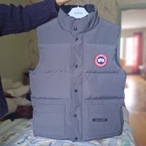 Canada goose väst - Säljer en ny/oanvänd canada goose väst, den är stl XS och färgen är grå/graphite. Alla tags och allting sitter fortfarande kvar.