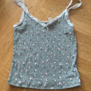 Spetsigt grönt linne  - Spetsigt grön linne med blommor på och luftigt material. Super smickrande. 