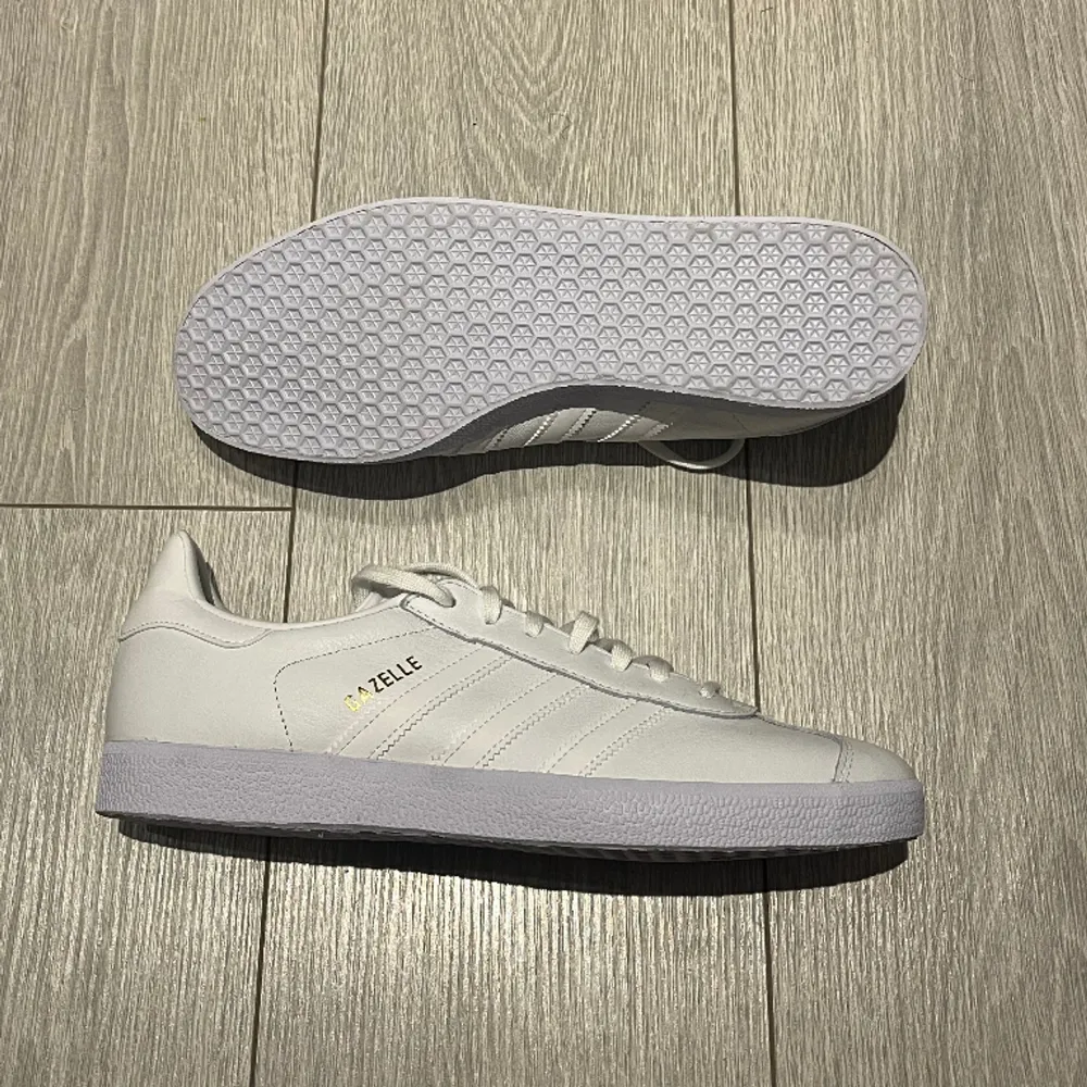 Säljer dessa ”Adidas Gazelle Originals” (White) i storlek 44 (US 10). Skorna är helt oanvända och köptes från ”adidas.com” för 1250 kr. Om ni är intresserade av att köpa skorna eller vill ha mer information så får ni gärna höra av er!. Skor.