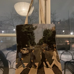 Tygväska från Ivan Alexis - Otrolig tygväska köpt i Köpenhamn. Använd men k gott skick. The Beatles tryck på framsidan. Väskan kan stängas med hjälp av en knapp samt att den har en liten innerficka. 