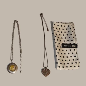 Trendiga halsband - Den prickiga satin sjalen av märket "Montini" är helt ny och oanvänd med prislapp och ursprunglig förpackning.  Berlocken har använts få gånger och är därav i skick som ny.  Halsbandet med hjärtat är använt många gånger!  Totalt nypris: ca 70 kr