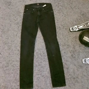 Svarta Slim Luke Jeans - Ett par stilrena slim jeans från Lee. Jeansen är svarta har passformen slim och storleken W28 och L32.